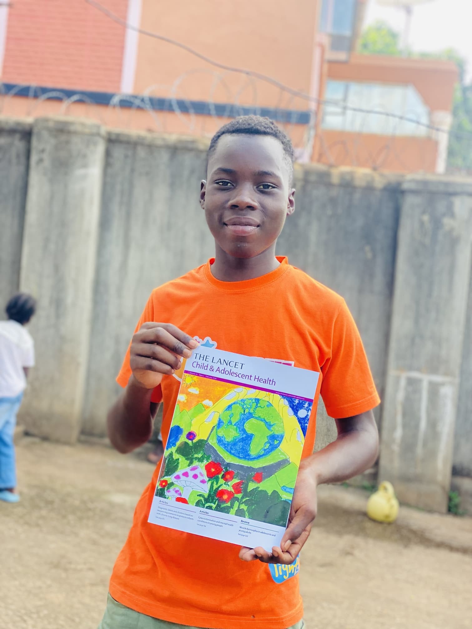 Young artist holding a copy of The Lancet Child & Adolescent Health